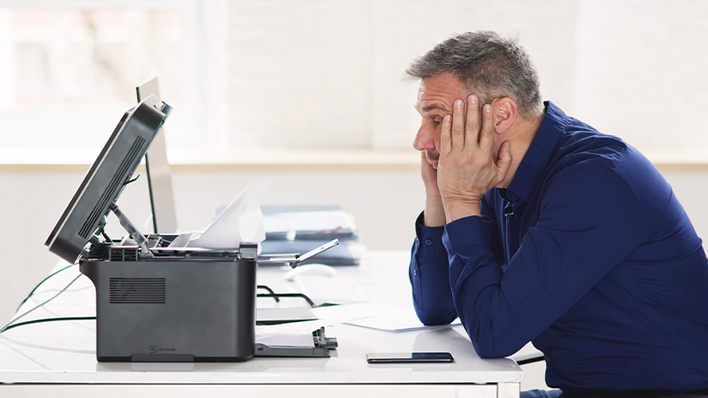 Uomo guarda stampante non funzionante